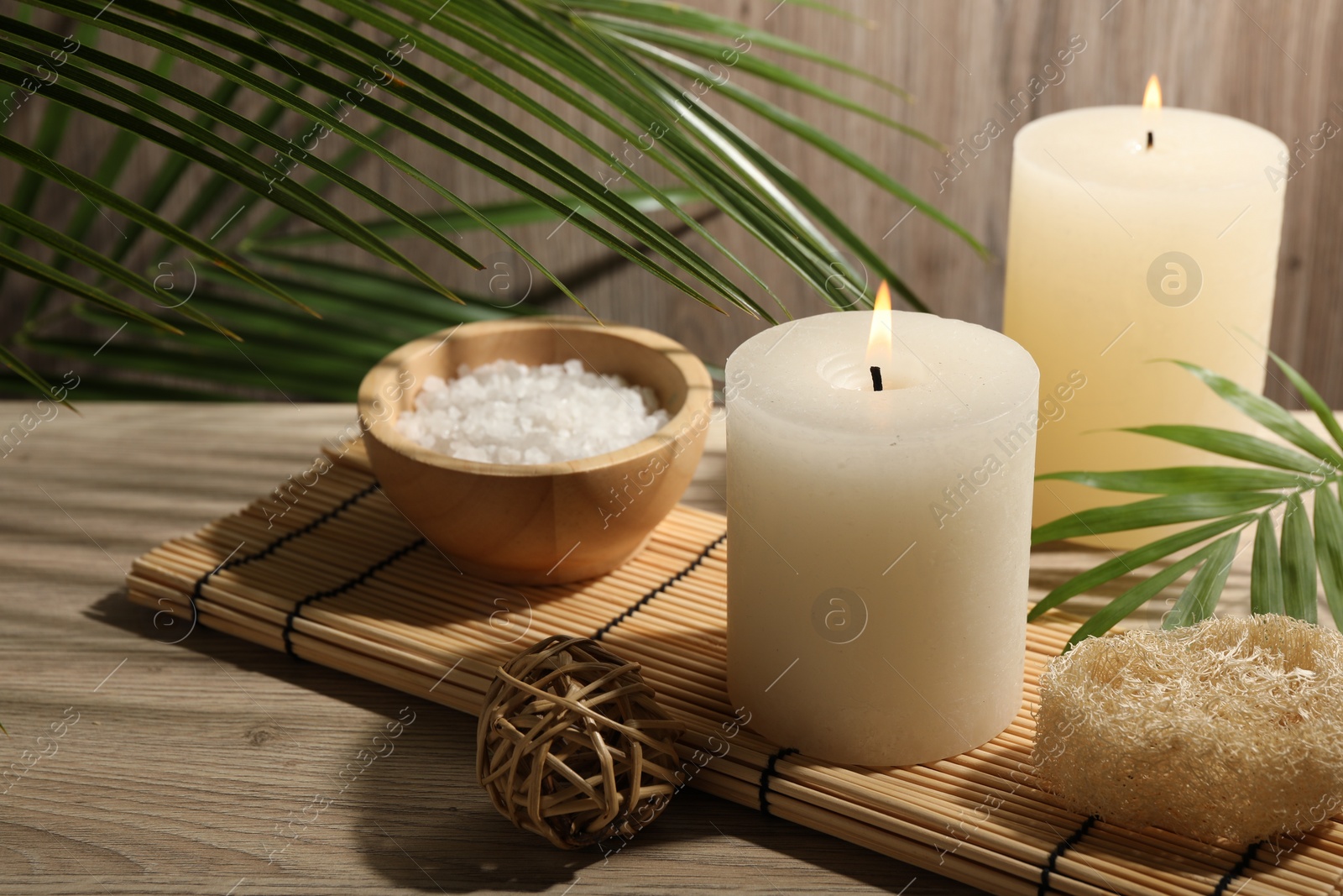 Photo of Composition with spa supplies and palm leaves on wooden table