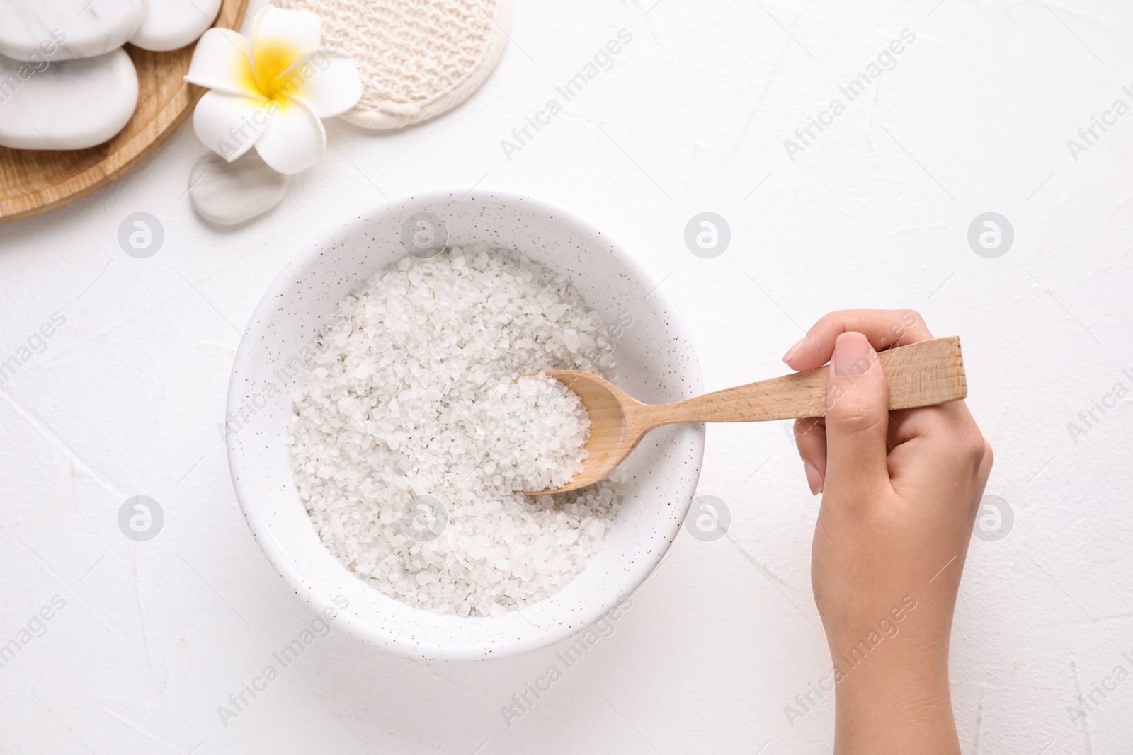 Photo of Woman with bowl of sea salt on white background, top view. Spa treatment