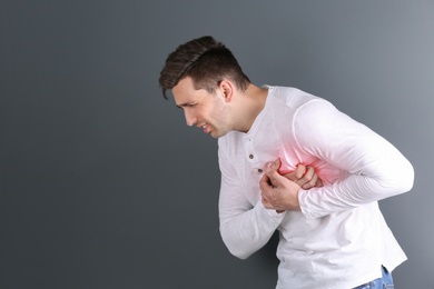 Photo of Young man having heart attack on gray background