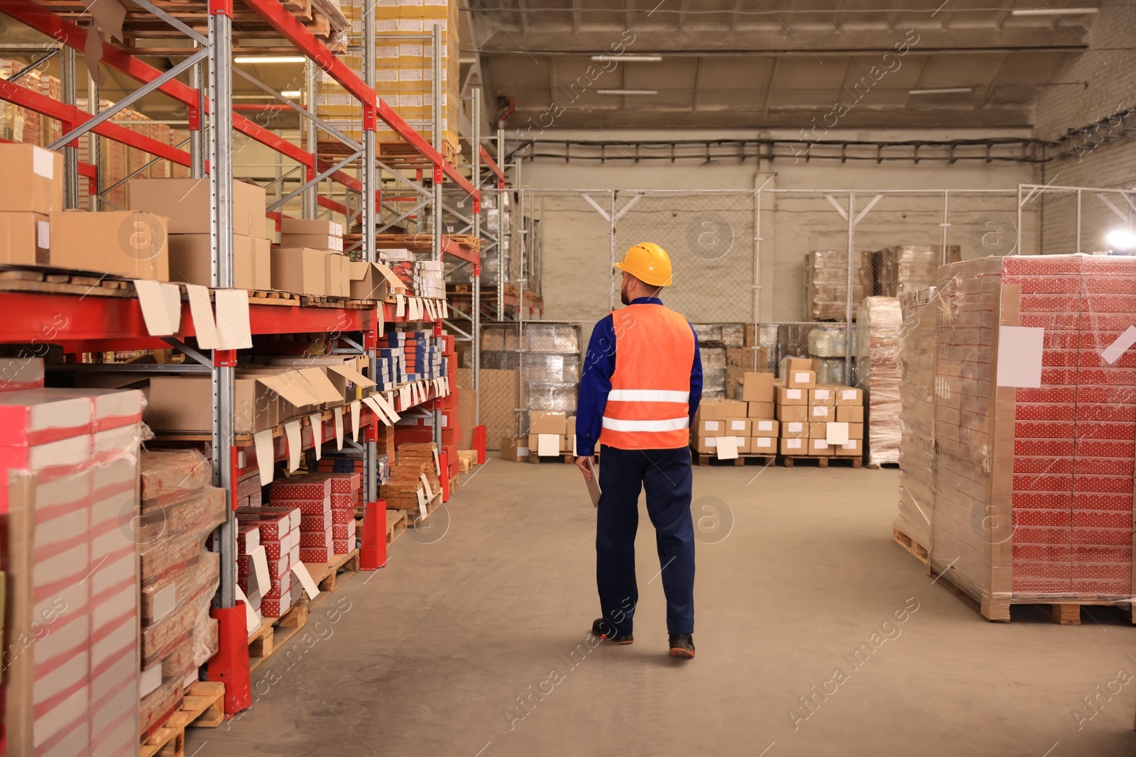 Image of Man with tablet working at warehouse, back view. Logistics center