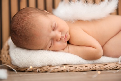 Photo of Cute newborn baby as Christmas angel in decorated studio