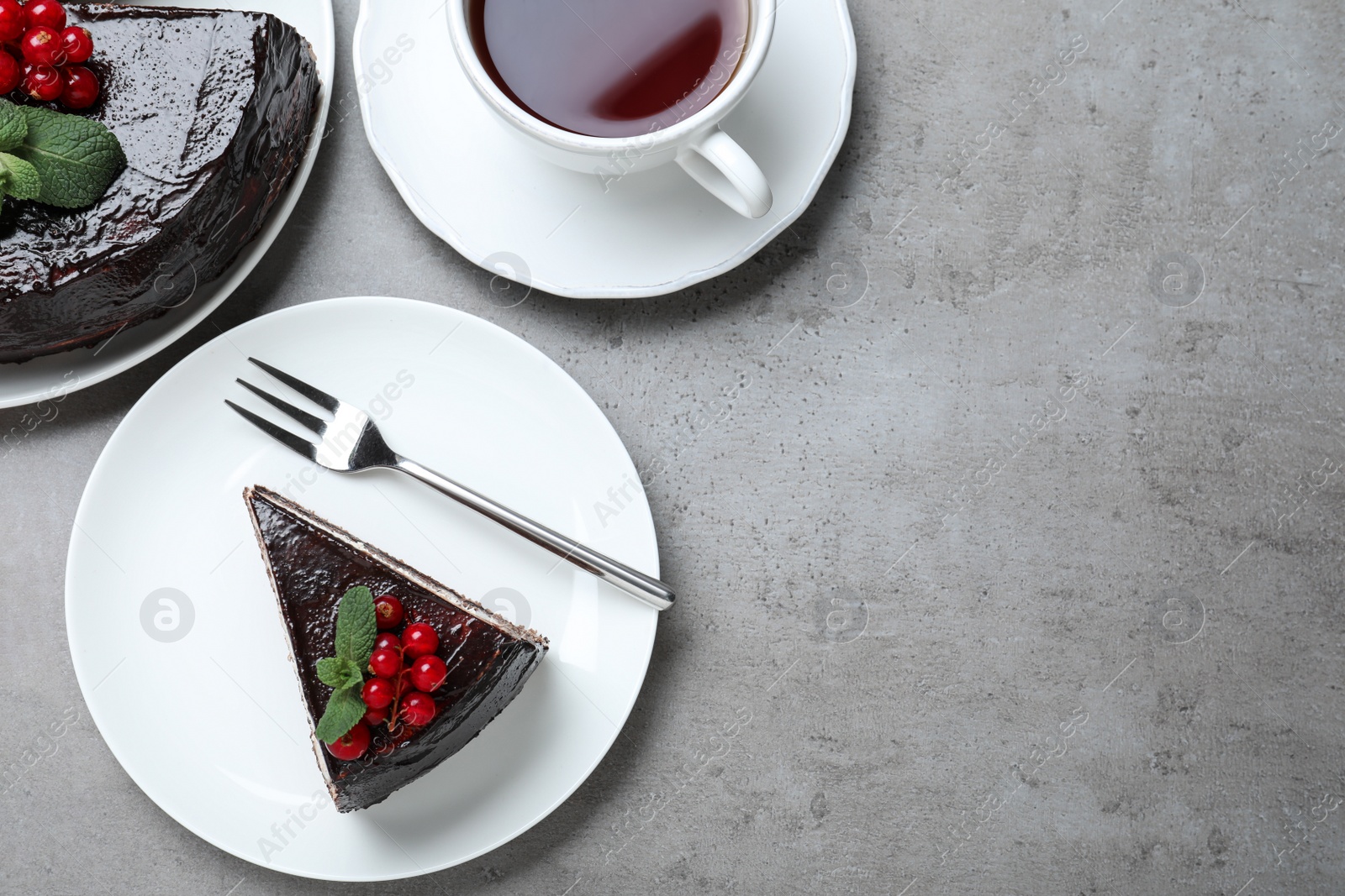 Photo of Tasty chocolate cake with berries on grey table, flat lay. Space for text