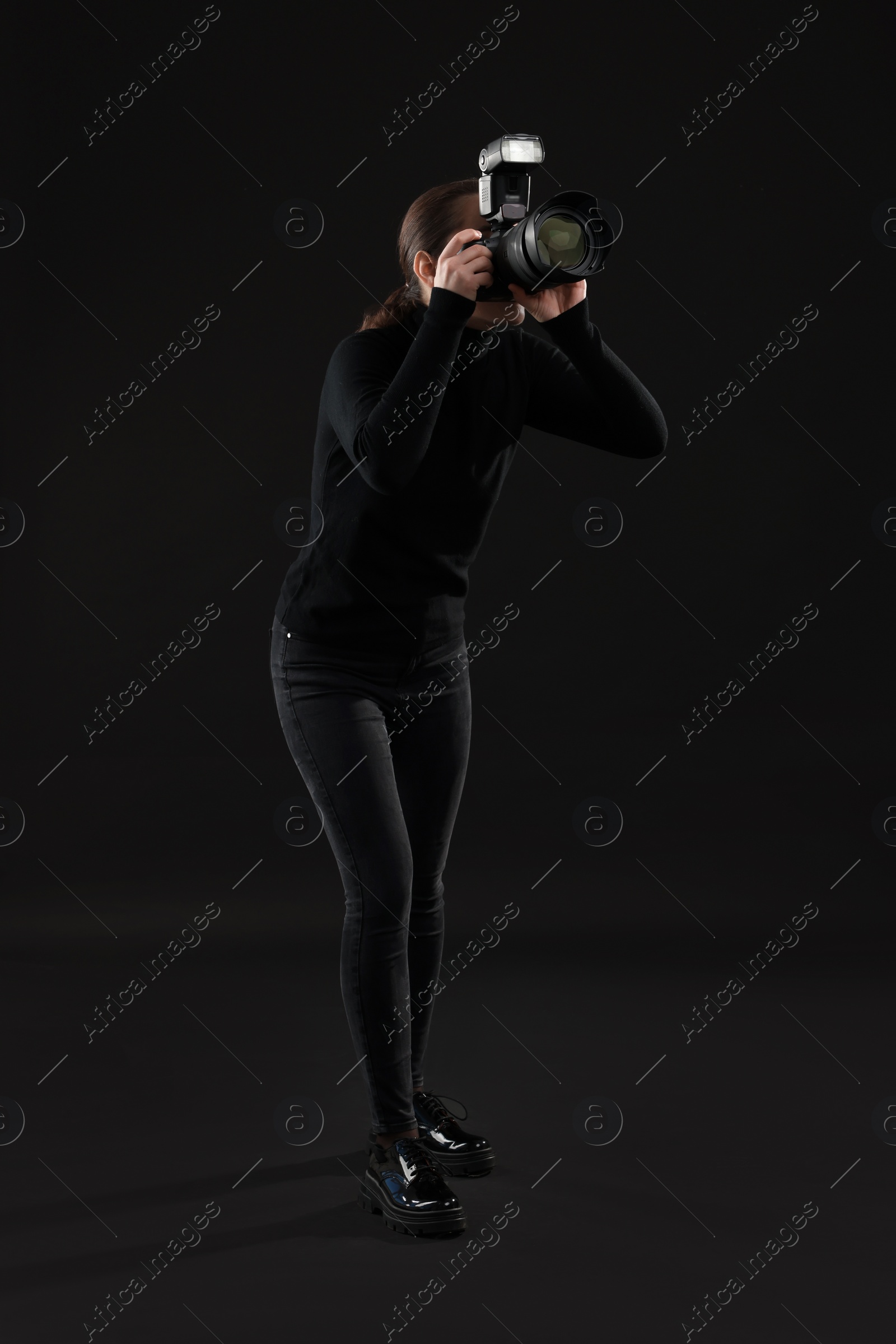 Photo of Professional photographer taking picture on black background