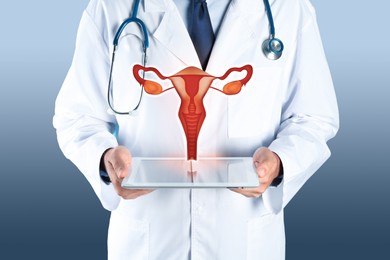 Image of Doctor demonstrating virtual icon with illustration of female reproductive system on color background, closeup. Gynecological care 