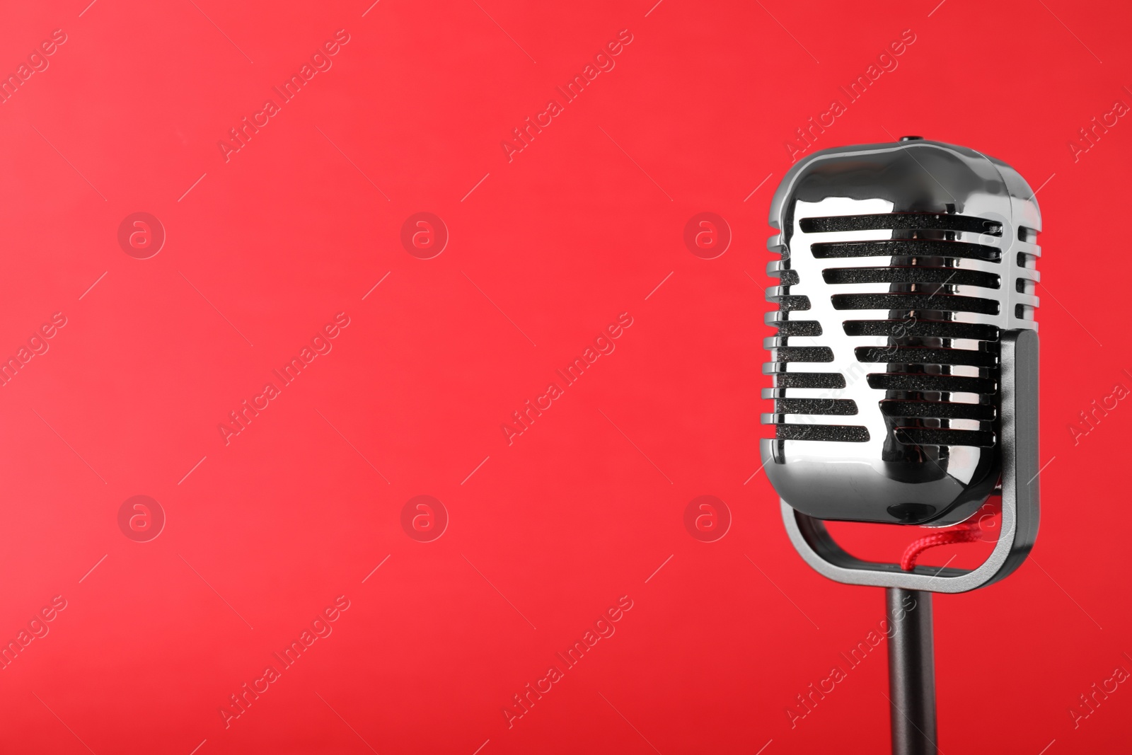 Photo of Retro microphone on color background, space for text