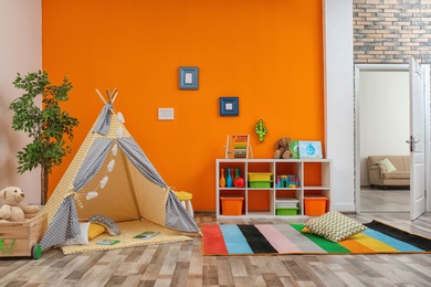 Photo of Cozy kids room interior with play tent and toys