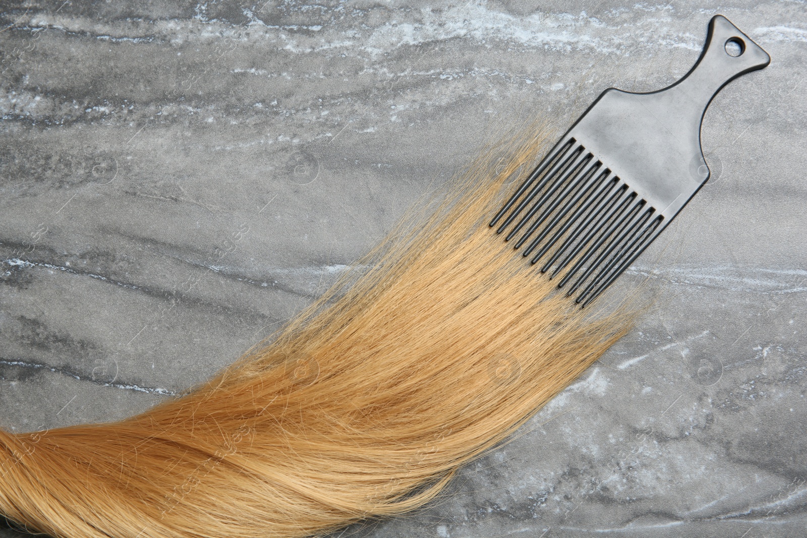 Photo of Flat lay composition with strand of hair and comb on grey background. Space for text