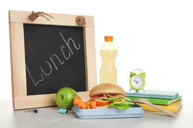 Composition with lunch box and food on table against white background