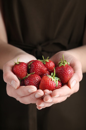 Photo of Woman holding many tasty fresh strawberries, closeup