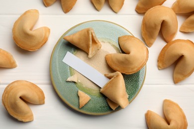 Photo of Tasty fortune cookies and paper with prediction on white wooden table, flat lay. Space for text