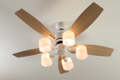 Photo of Modern ceiling fan with lamps indoors, below view