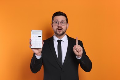 Photo of Emotional accountant with calculator on orange background