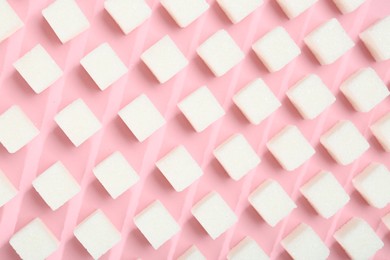 Photo of White sugar cubes on pink background, top view