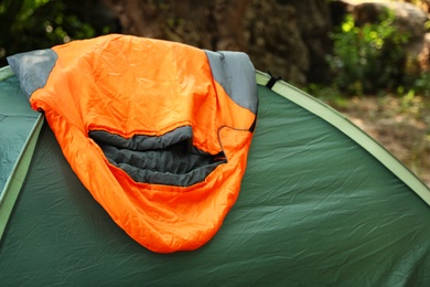 Photo of Tent with sleeping bag outdoors. Camping gear