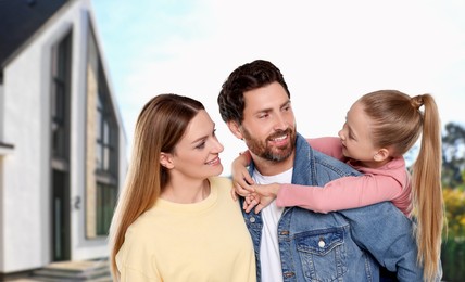 Image of Portrait of happy family with child near house