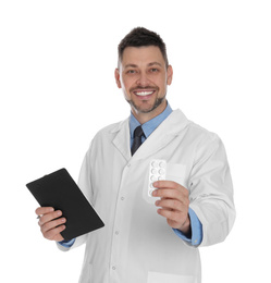 Professional pharmacist with pills and clipboard on white background