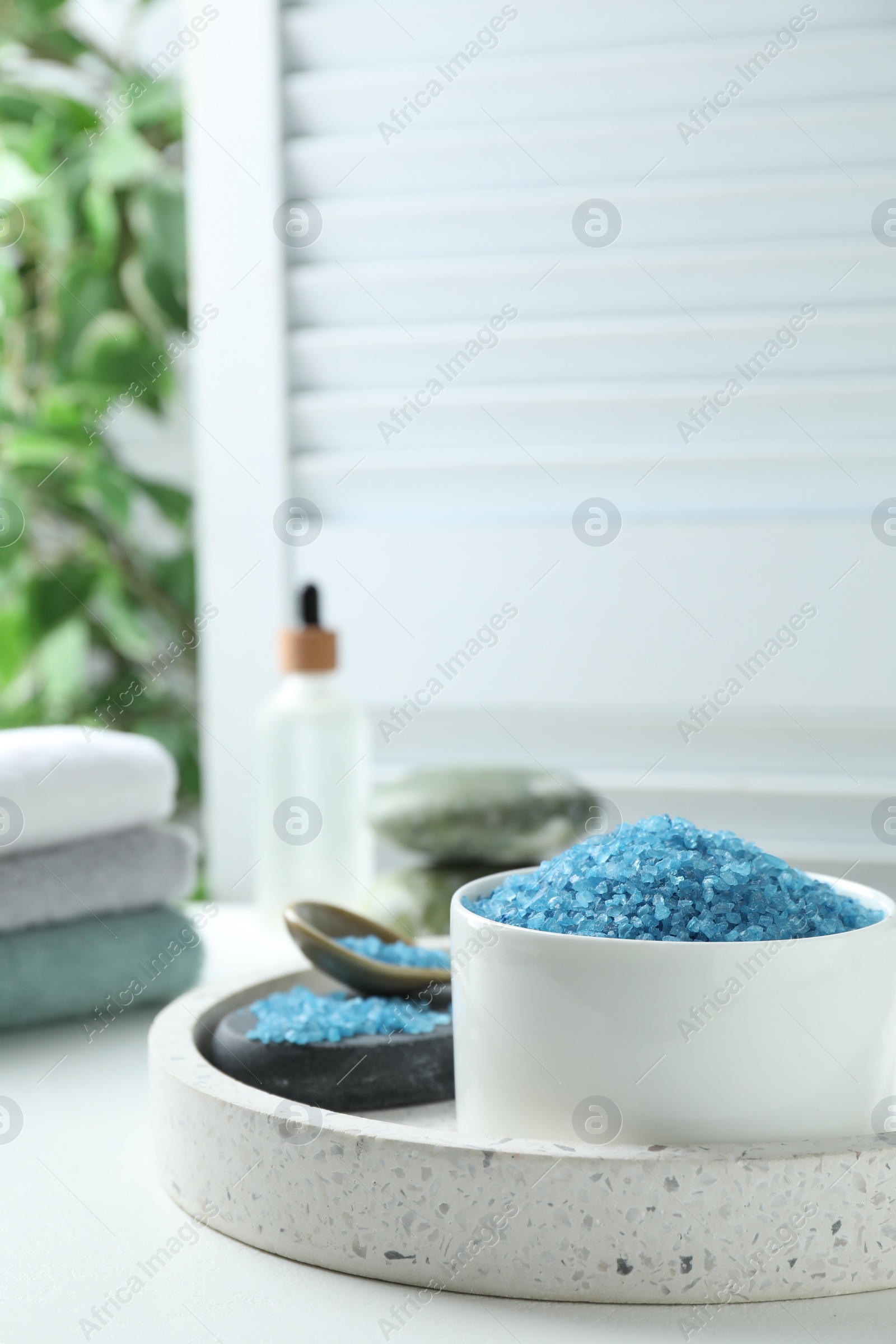 Photo of Blue sea salt on white table indoors, space for text