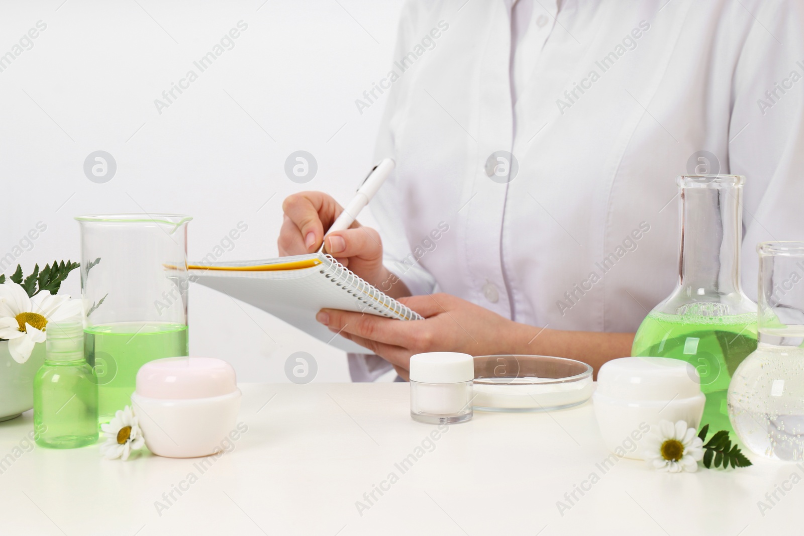 Photo of Female dermatologist doing research for new skin care product at table, closeup