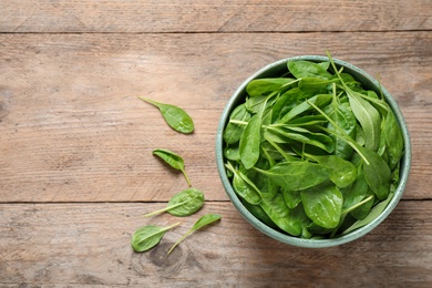 Photo of Fresh green healthy spinach on wooden table, flat lay. Space for text