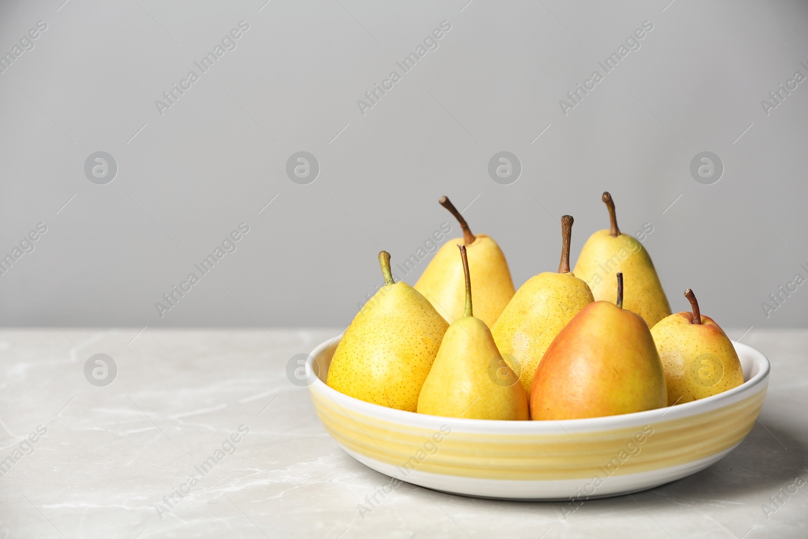 Photo of Plate with pears on table against grey background. Space for text