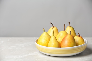 Plate with pears on table against grey background. Space for text