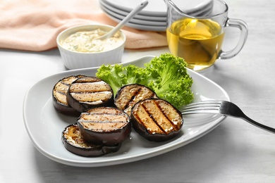 Plate with fried eggplant slices on table