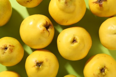 Photo of Tasty ripe quinces on light green background, flat lay