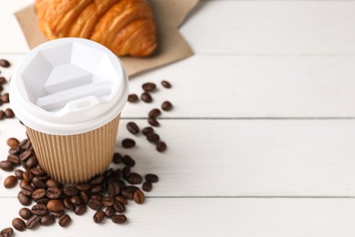 Photo of Coffee to go. Paper cup with tasty drink, croissant and beans on white wooden table. Space for text