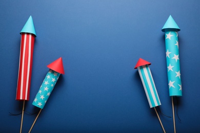 Photo of Firework rockets on blue background, flat lay with space for text. Festive decor