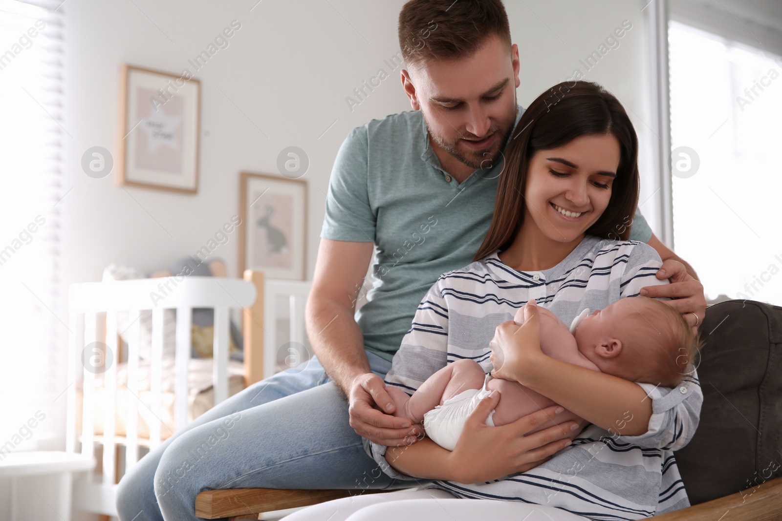 Photo of Happy couple with their newborn baby at home