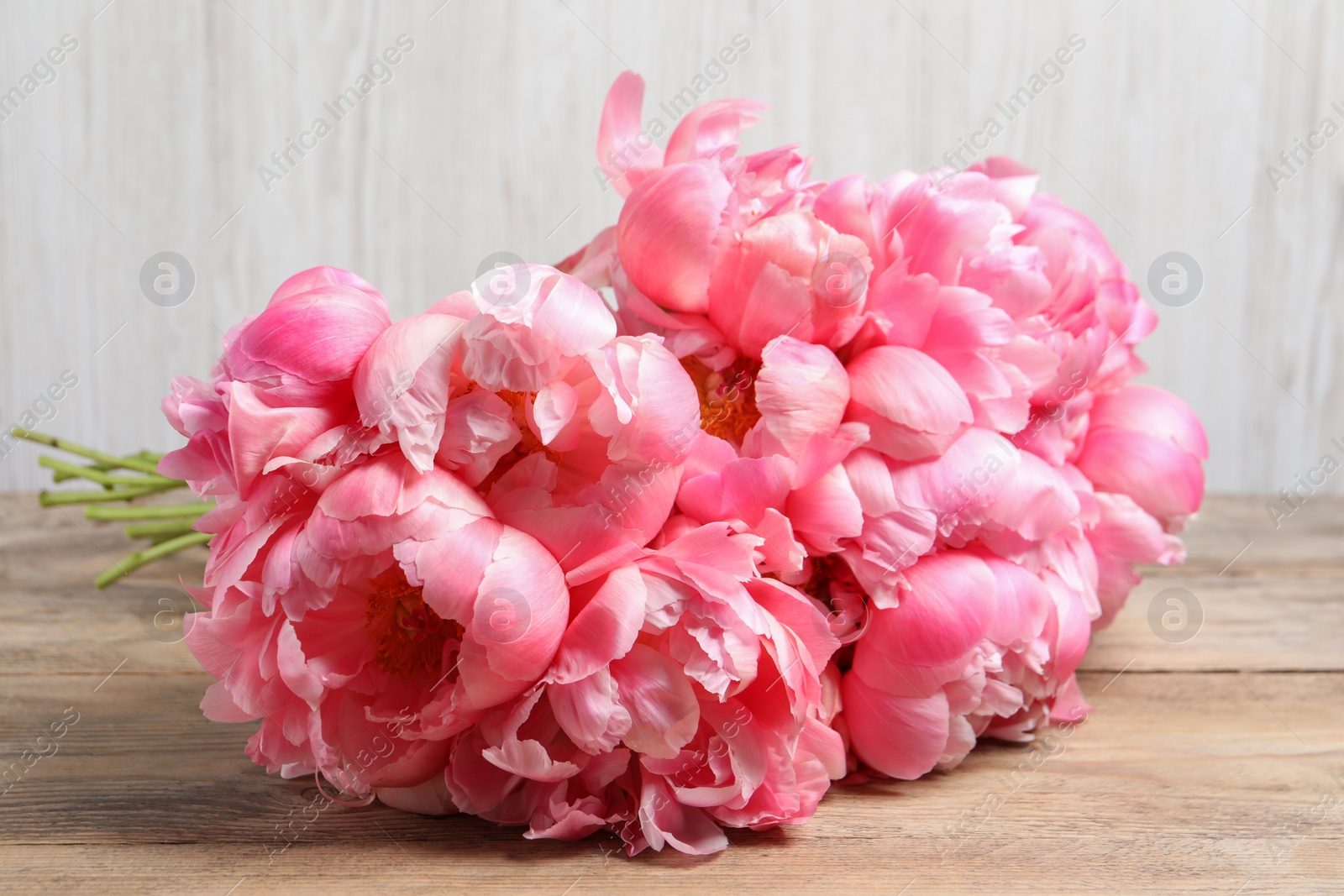 Photo of Bunch of beautiful pink peonies on wooden table