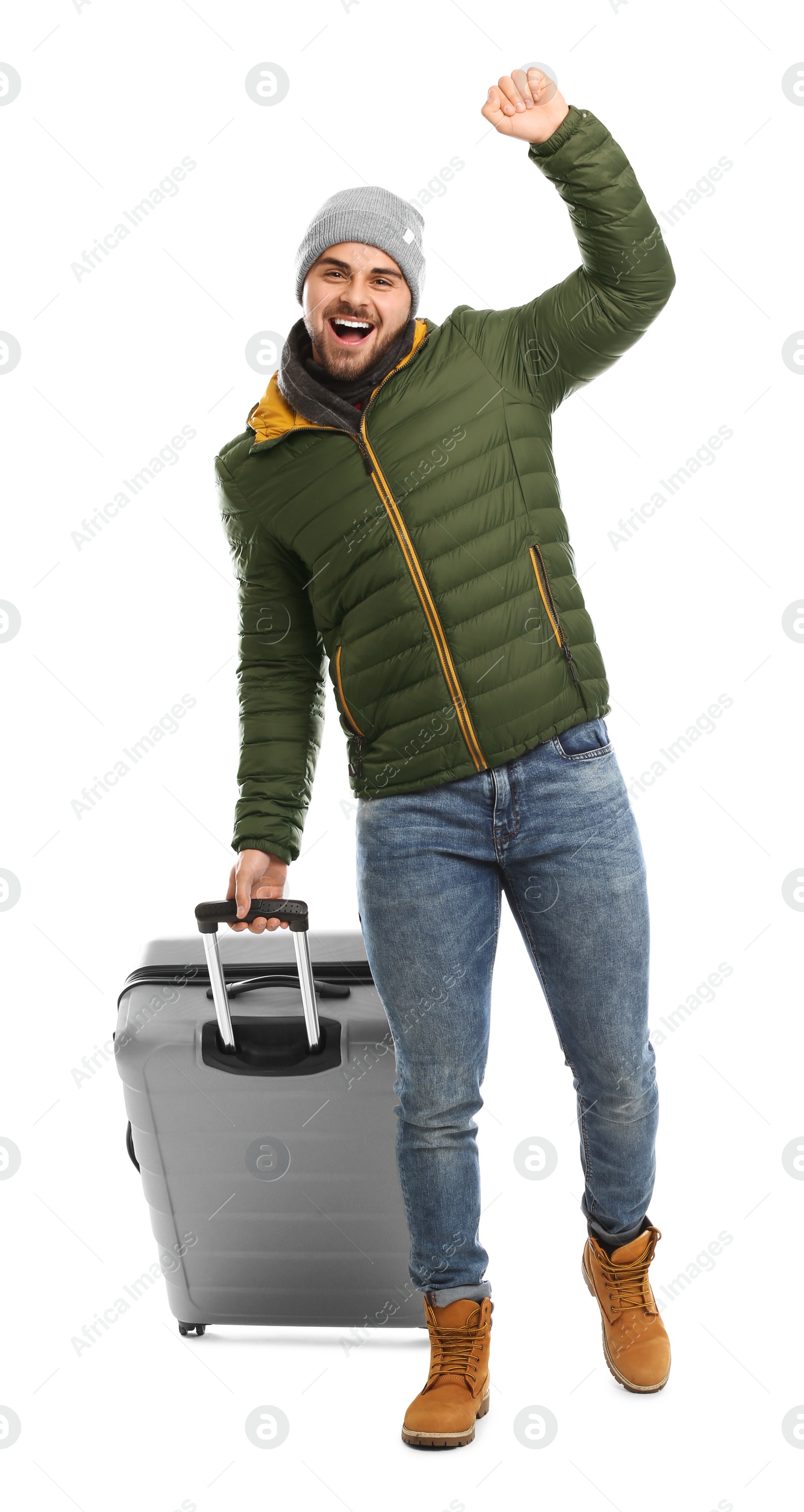 Photo of Young man in warm clothes with suitcase on white background. Winter vacation