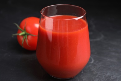 Delicious fresh tomato juice on black table, closeup