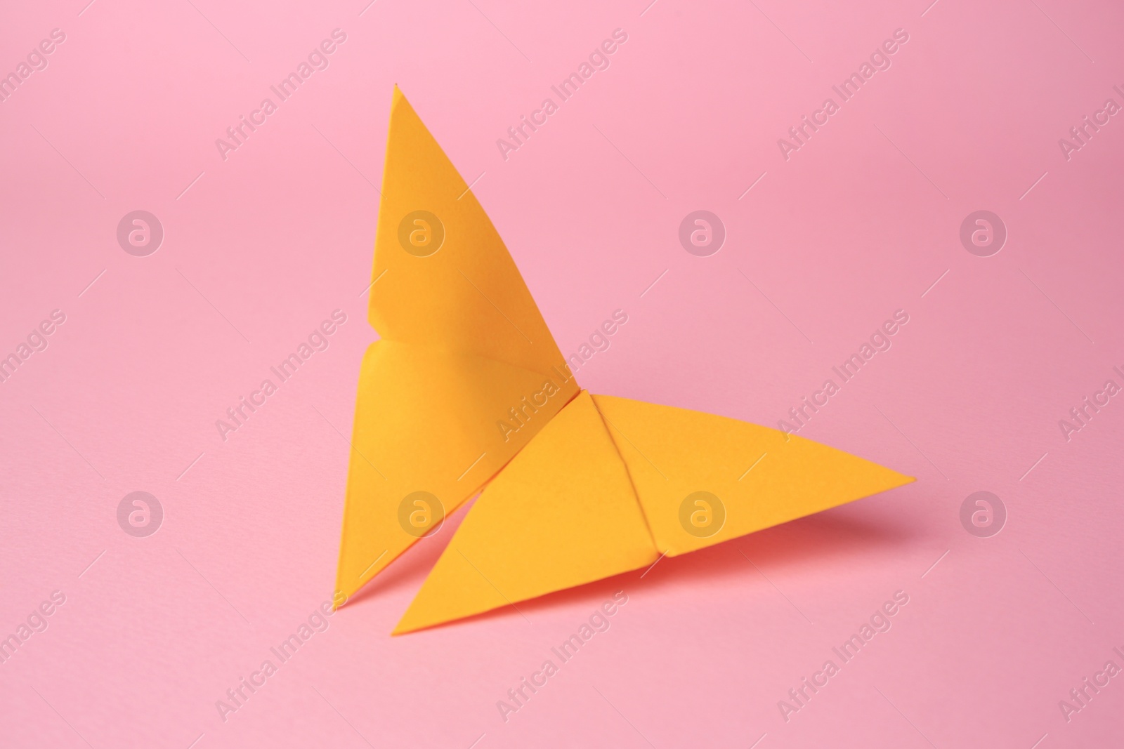 Photo of Origami art. Paper butterfly on pink background