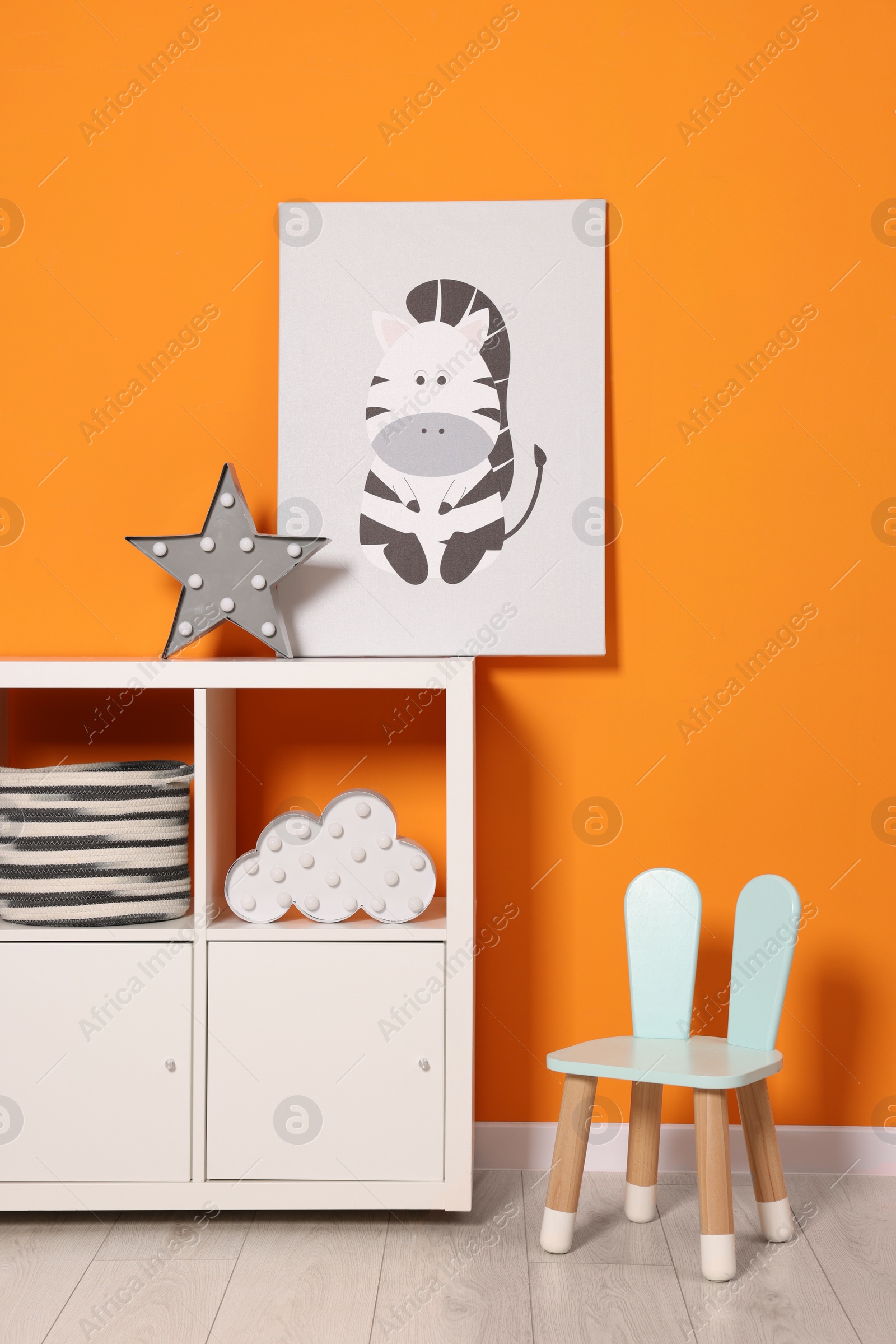 Photo of Beautiful children's room with bright orange wall and furniture. Interior design