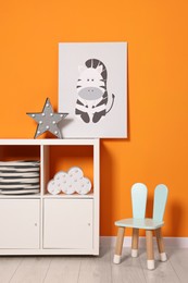 Photo of Beautiful children's room with bright orange wall and furniture. Interior design