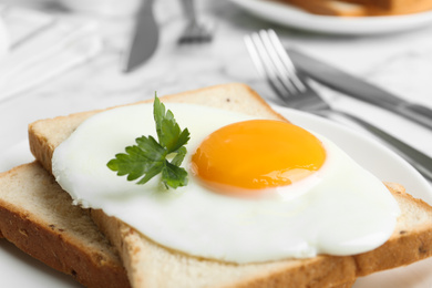 Photo of Tasty fried chicken egg with bread and parsley on plate, closeup