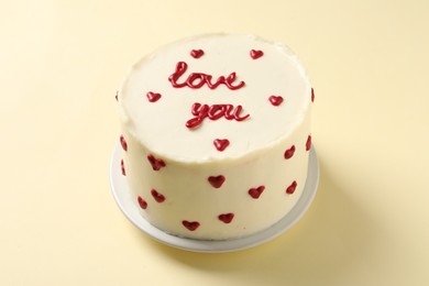 Photo of Bento cake with text Love You on beige table. St. Valentine's day surprise