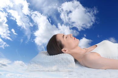 Woman sleeping on orthopedic pillow against blue sky