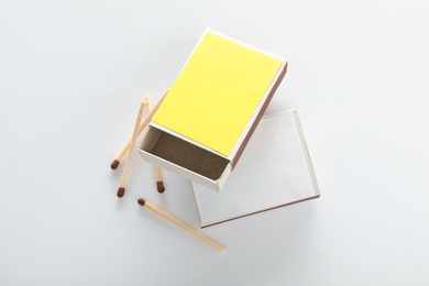 Cardboard boxes and matches on white background, top view. Space for design