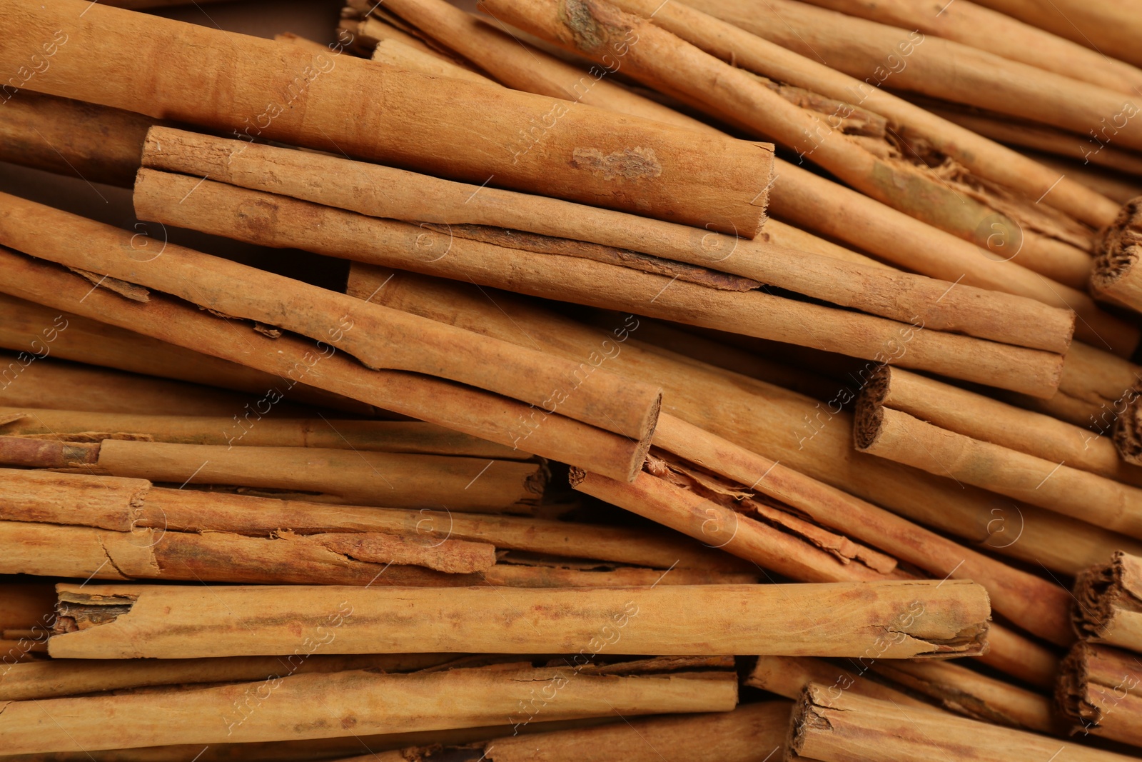 Photo of Aromatic cinnamon sticks as background, top view