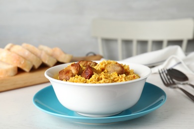 Photo of Bowl of tasty rice pilaf with meat served on table