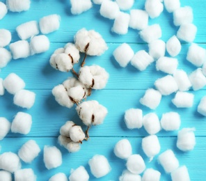 Photo of Flat lay composition with cotton balls and flowers on blue wooden background