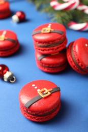 Photo of Beautifully decorated Christmas macarons on blue background