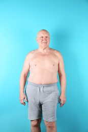 Photo of Fat senior man on color background. Weight loss