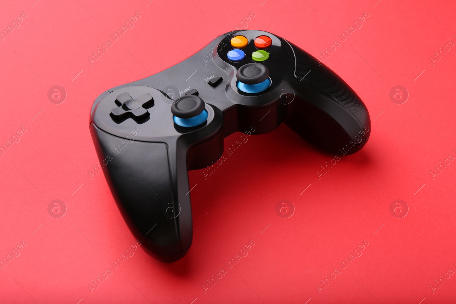 Photo of One wireless game controller on red background