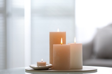 Burning candles on table indoors, space for text. Interior elements