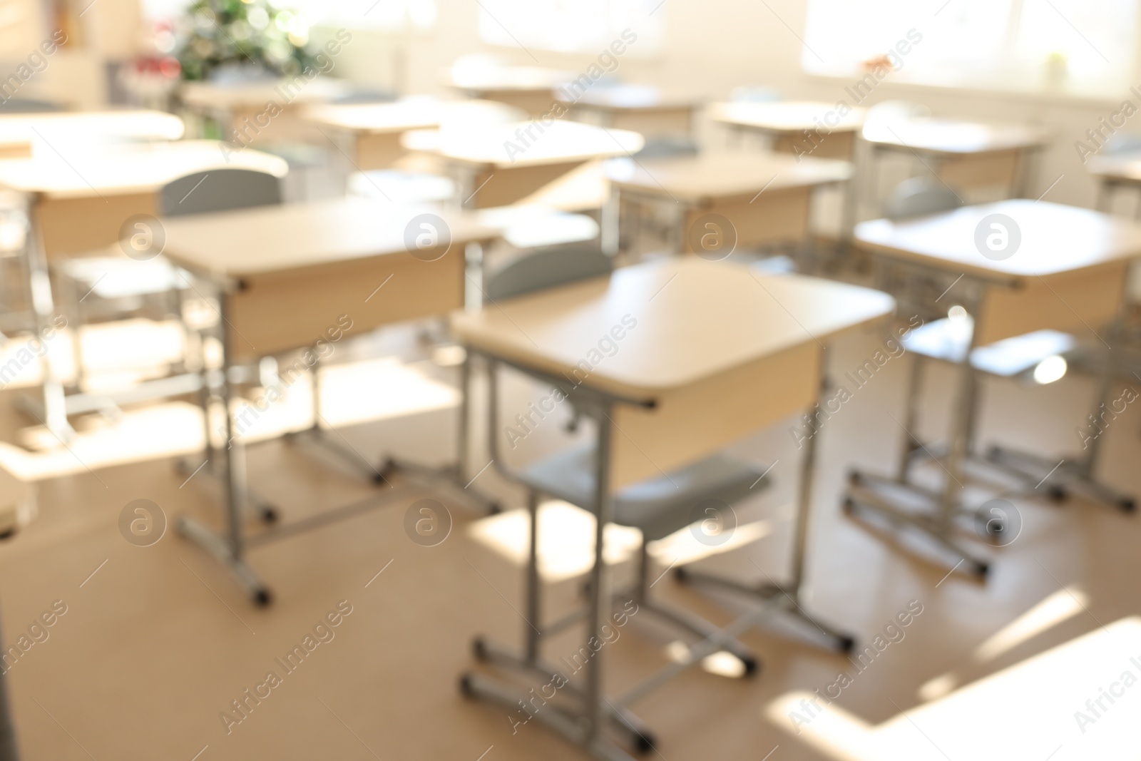 Photo of Blurred view of empty school classroom with desks and chairs