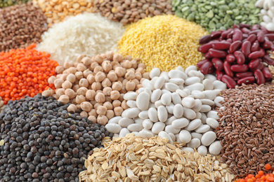 Different types of legumes and cereals as background, closeup. Organic grains