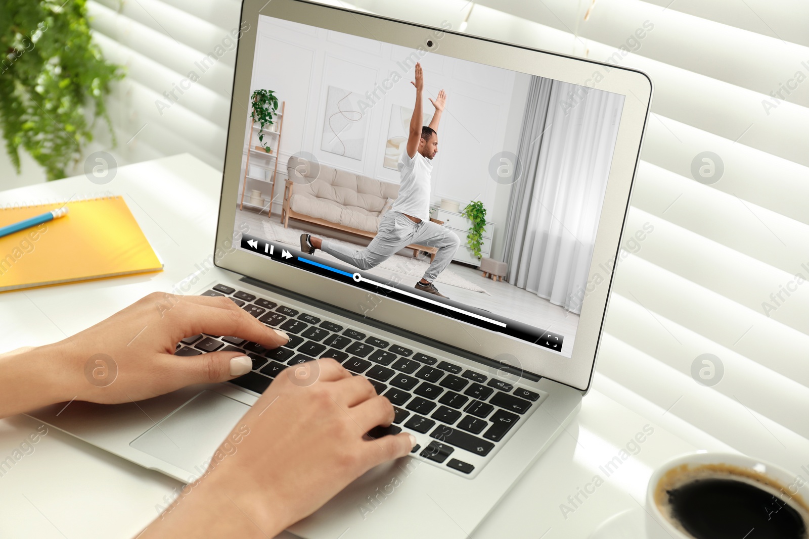 Image of Woman watching morning exercise video on laptop at table, closeup